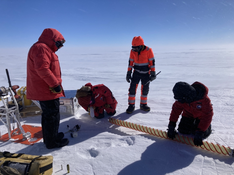 Researchers remove ice samples after the drilling process
